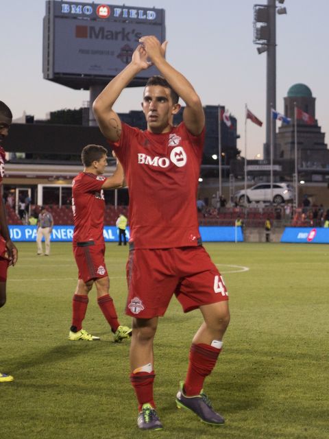Luca in a red Toronto FC #45 kit applauding the fans.