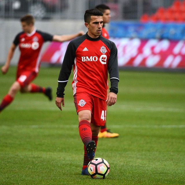 Luca with the ball in a red and black Toronto FC II #45 kit.